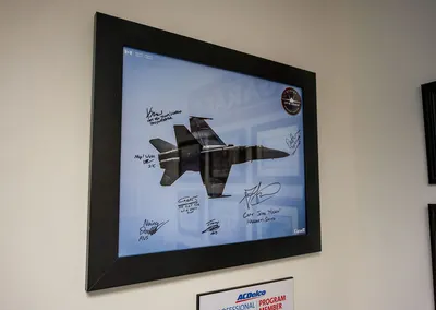 A signed, framed photo of a fighter jet