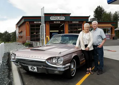 Jake and Marilyn Siemens with a classic car outside the shop