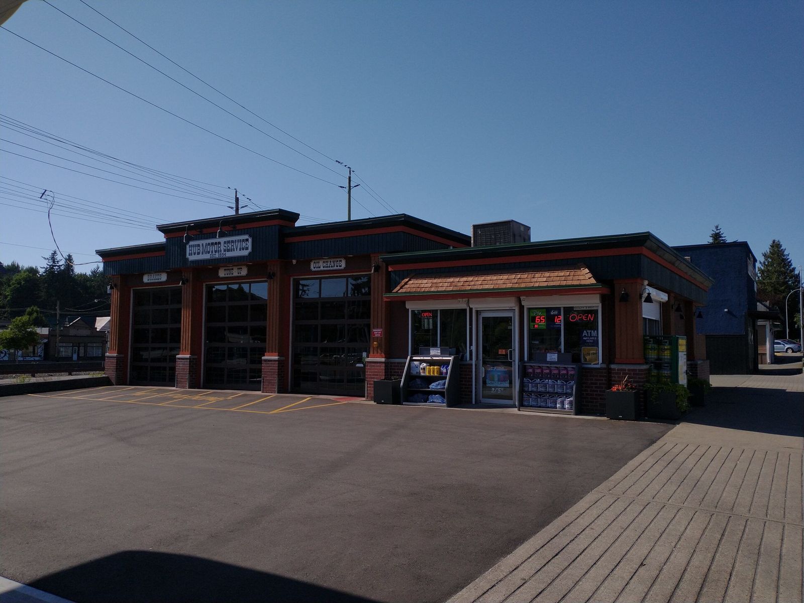 The front of Hub Motor Service, with three bay doors signed Brakes, Tune-up and Oil Change.