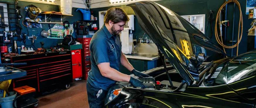 Technician working on a car in the shop