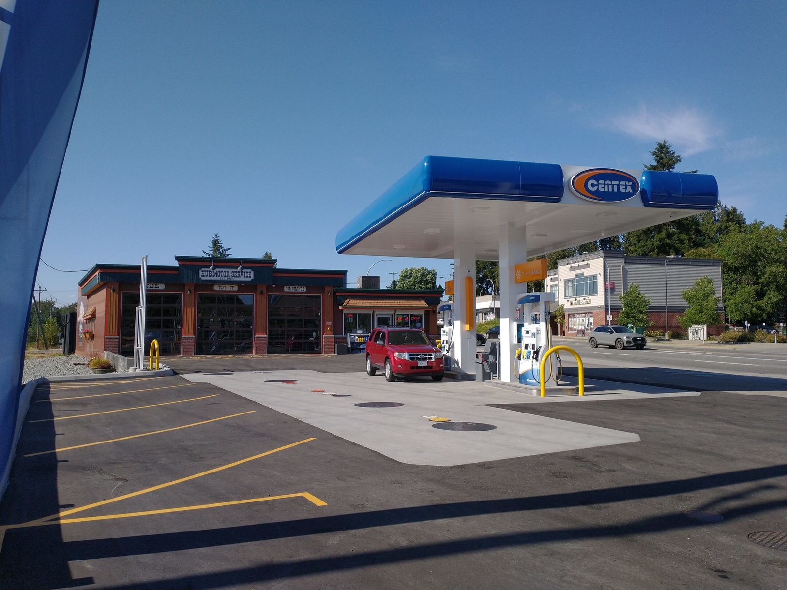 The Centex gas canopy and pumps, with the Hub Motor Service shop and three of its bay doors behind.