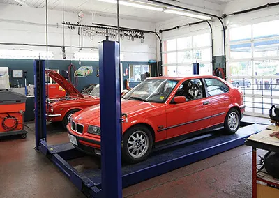 A red car on a lift in the service bay