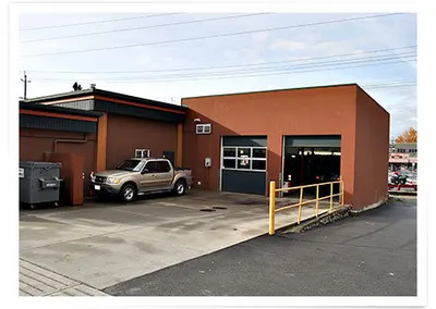 The back of the shop, with a pickup parked by the bay doors